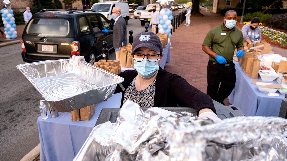 woman in a mask handing out food