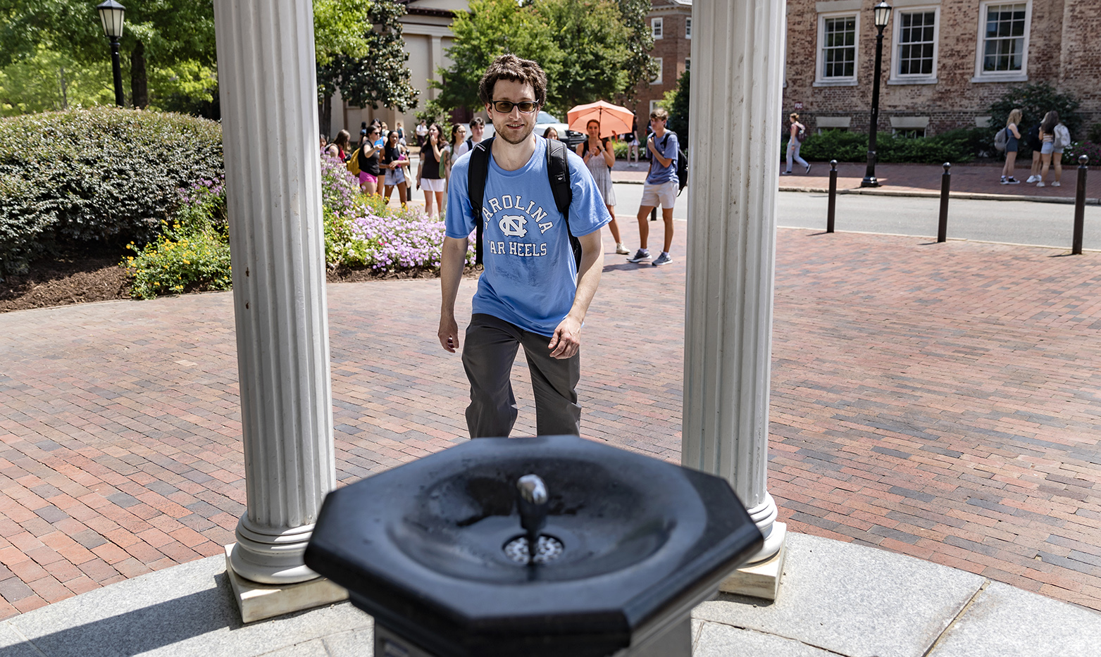 A student approaches the fountain of the Old Well on the campus of UNC-Chapel Hill.