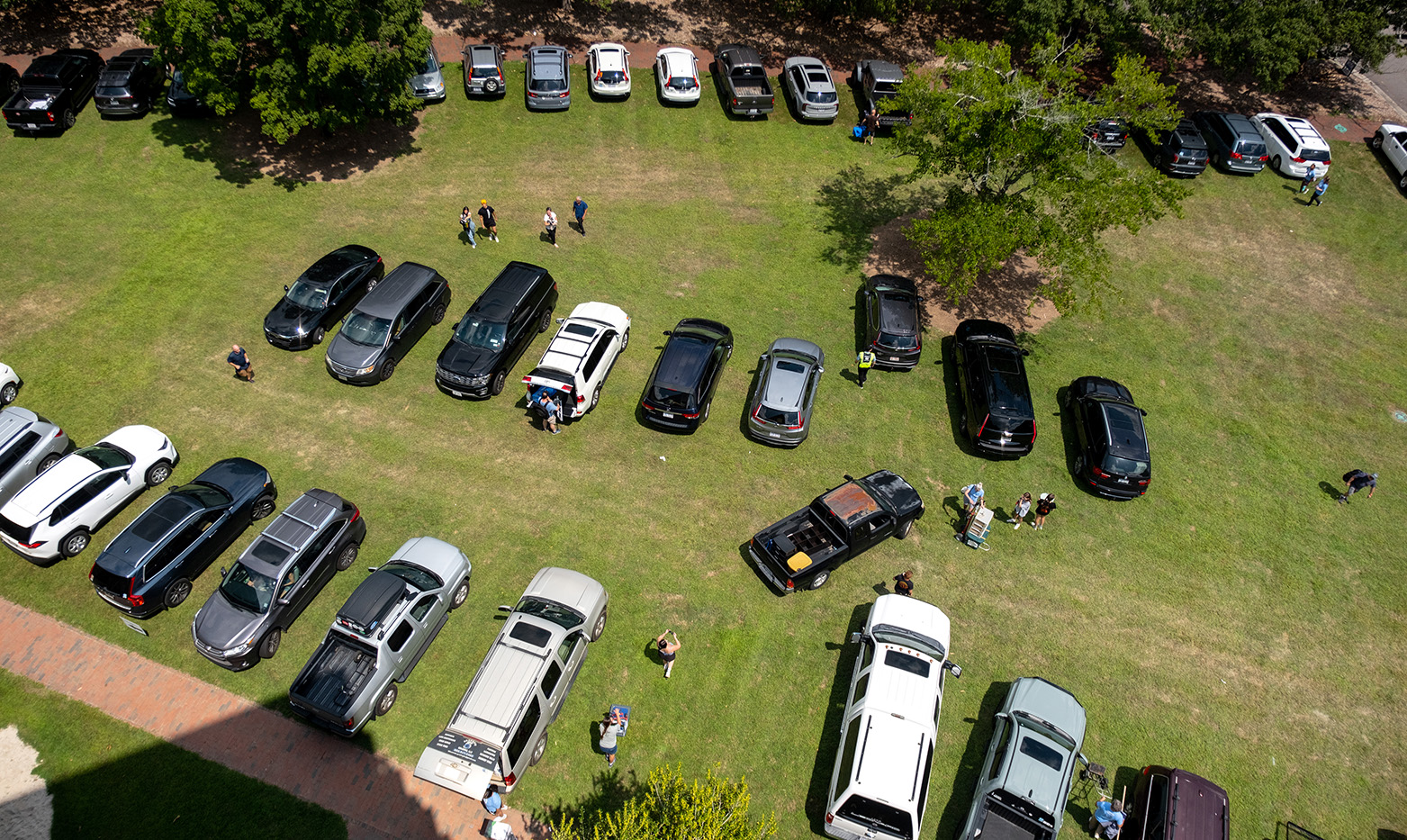 An aerial image of rows of cars parked on a large lawn.