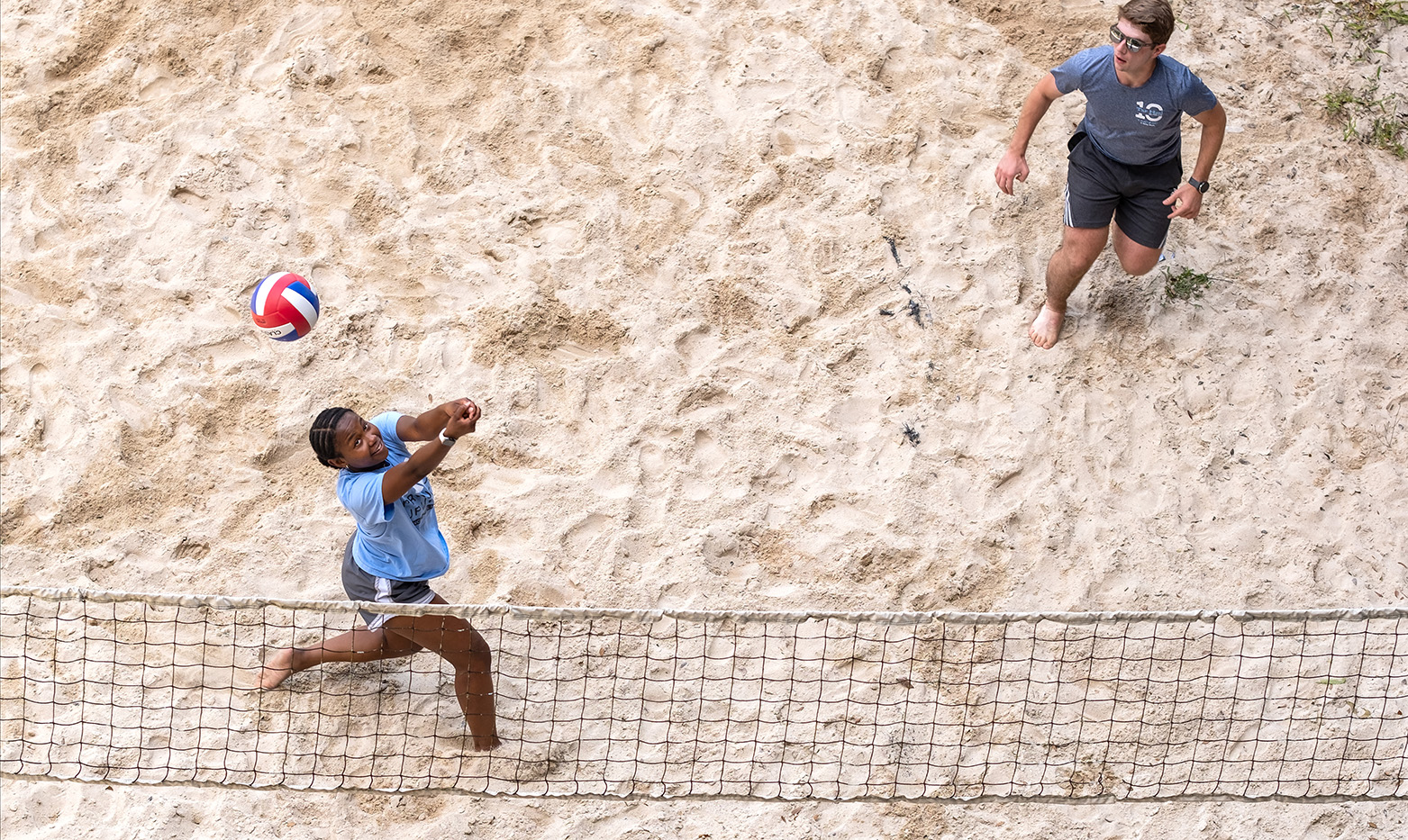 Aerial image of two students playing beach volleyball.