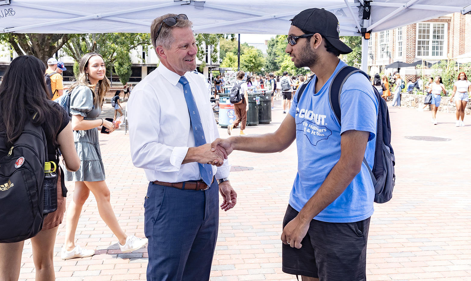 A man, UNC-Chapel Hill Chancellor Kevin M. Guskiewicz, shaking hands with a student.
