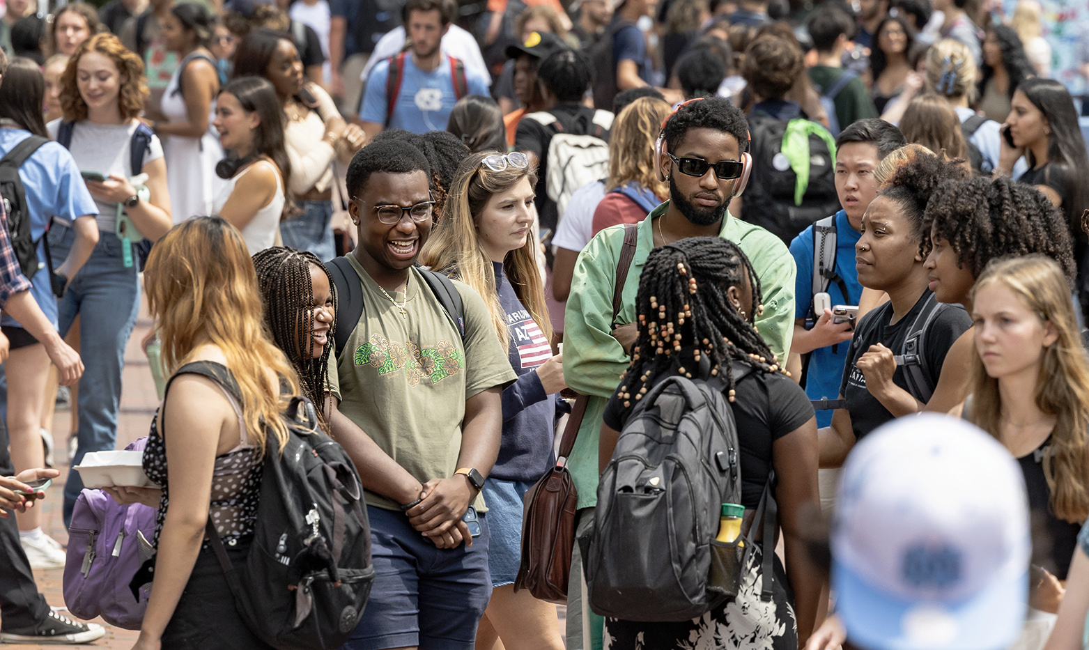 A crowd of students conversing around the Pit area on the campus of UNC-Chapel Hill.