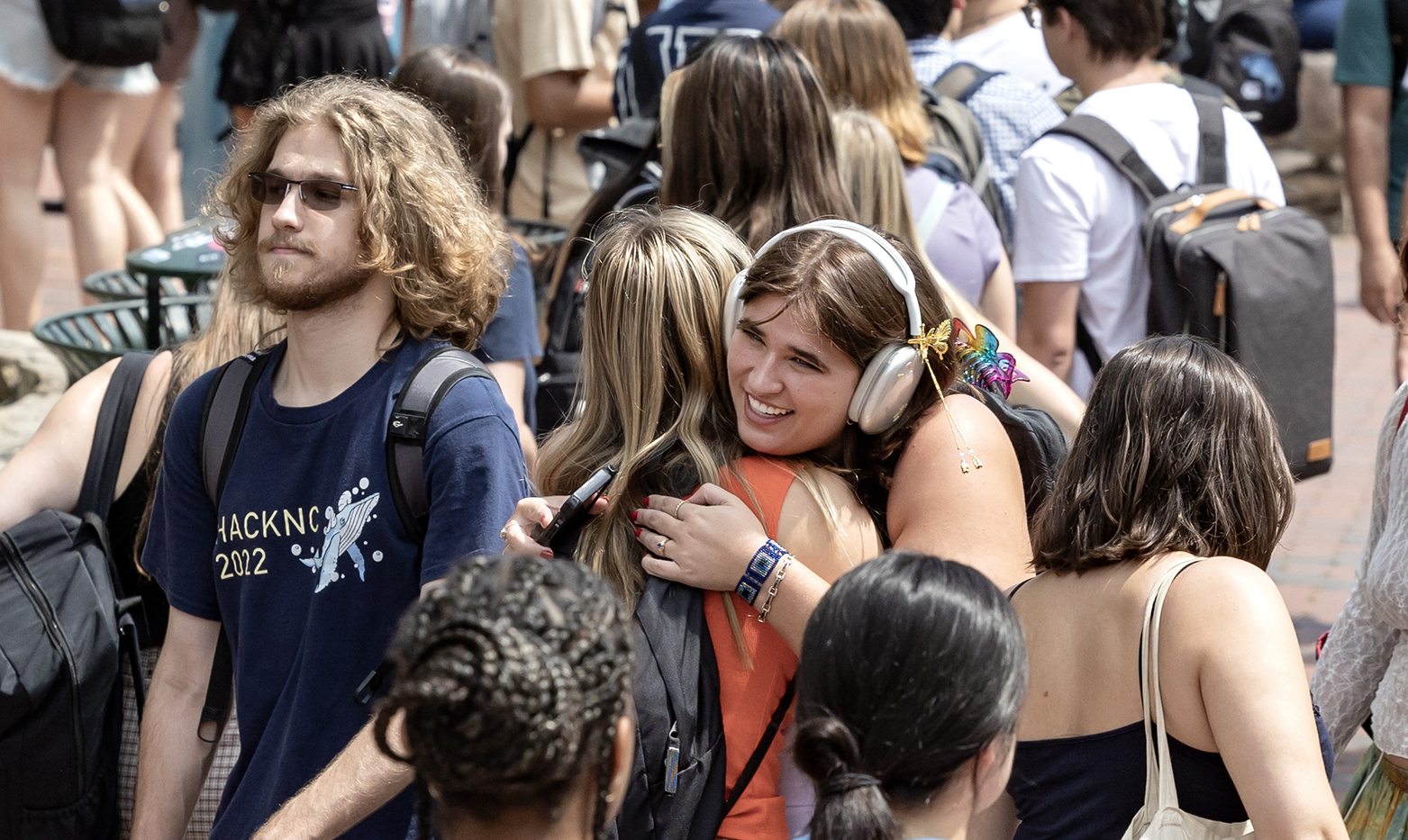 Two students hugging amongst a crowd of students on the campus of UNC-Chapel Hill.