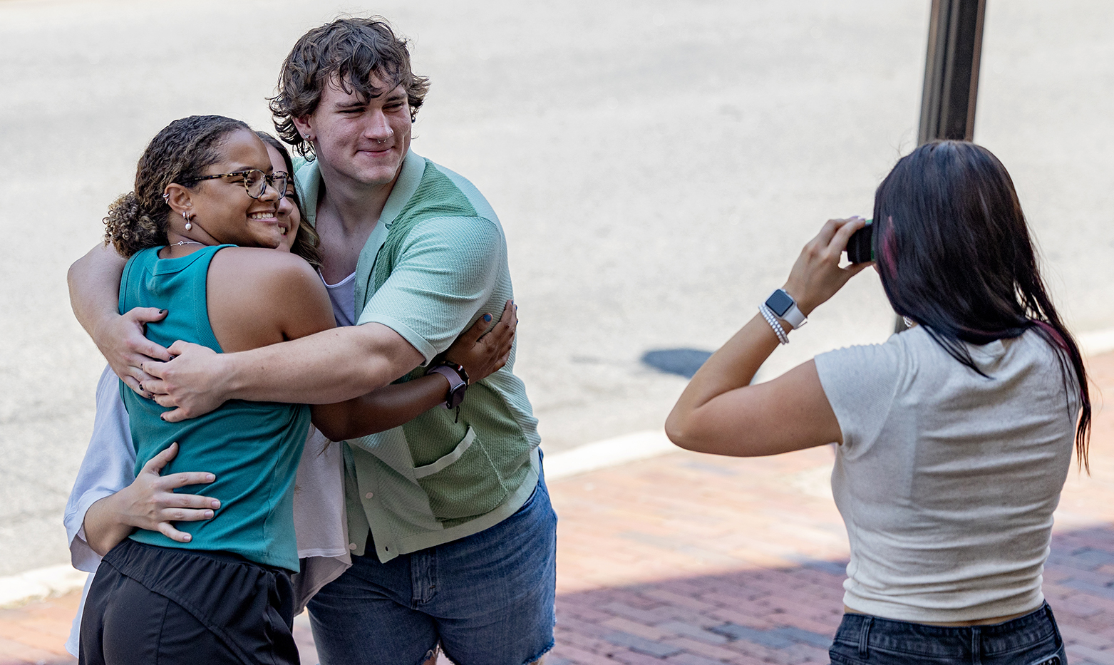 Two students hugging while having their picture taken.
