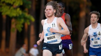 Cross country runner, Parker Wolfe, runs ahead of competition close behind him with a name tag reading 