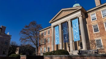 Exterior of South Building on the campus of UNC-Chapel Hill with Carolina Blue and Navy Blue banners.