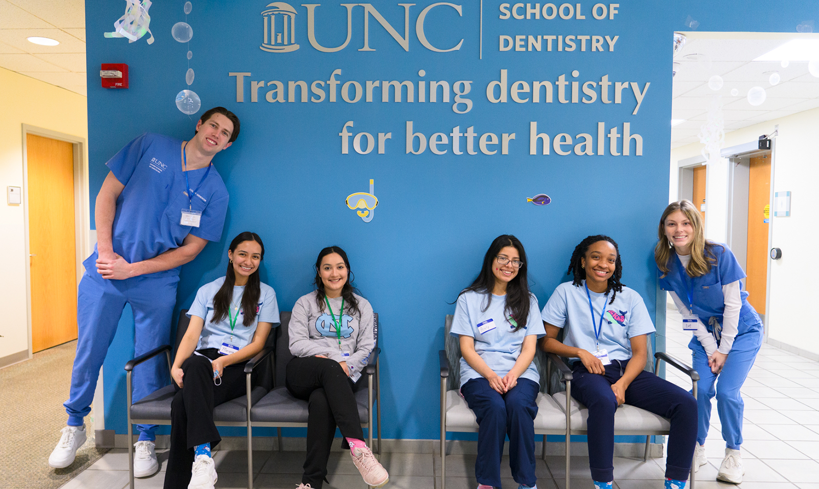 Dentistry students posing in front of sign that says 