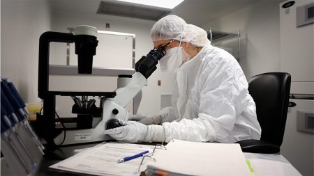 Doctor looking through microscope.