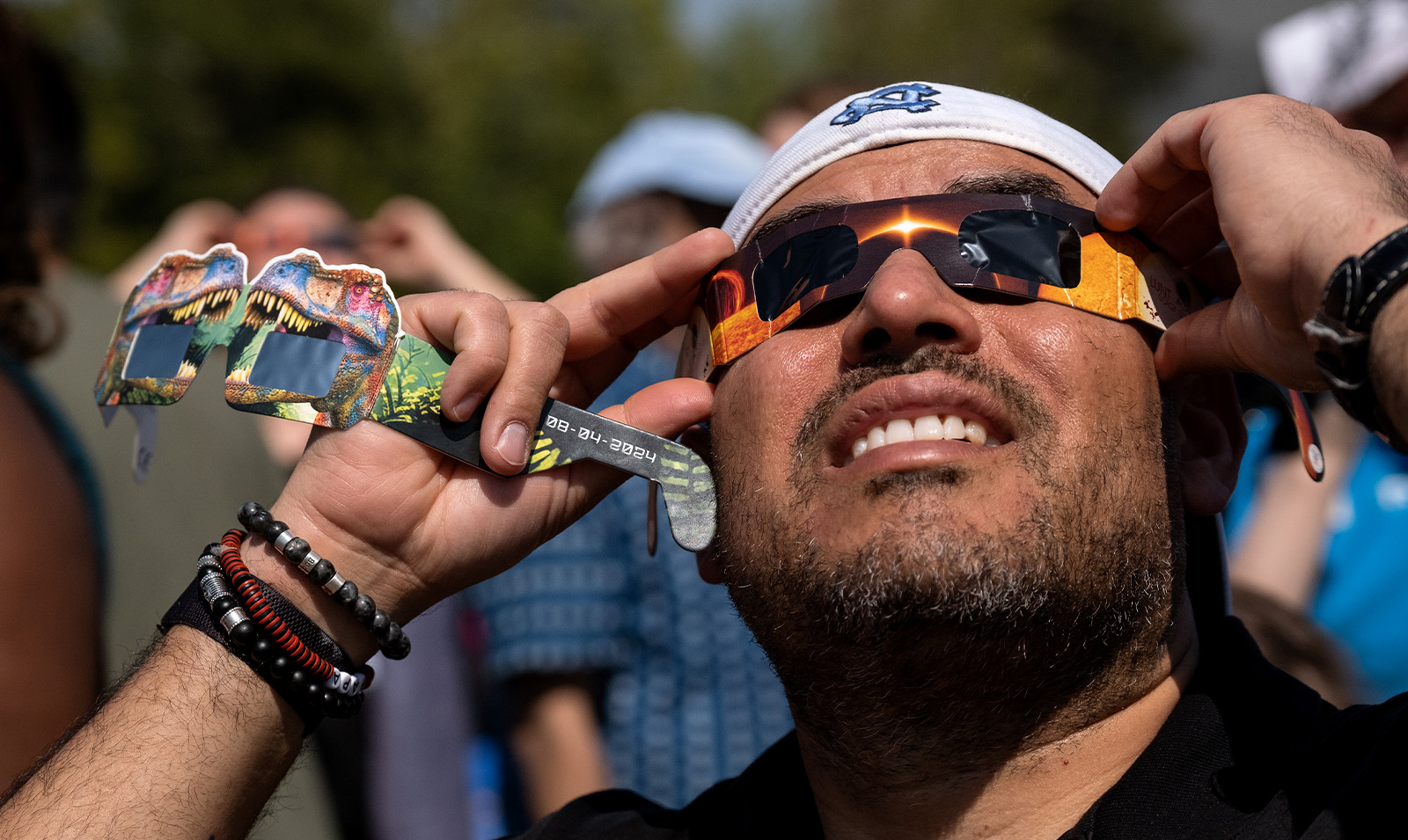 A man looking up a solar eclipse while wearing safety sunglasses.