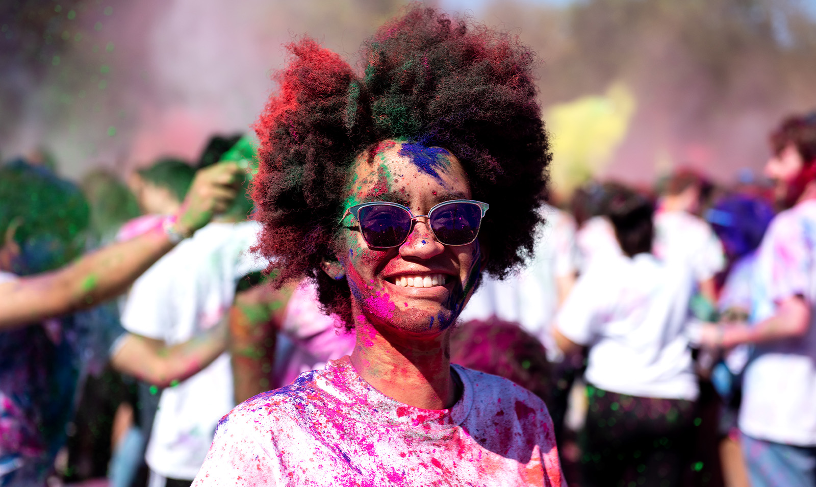 A student covered in paint celebrating Holi.