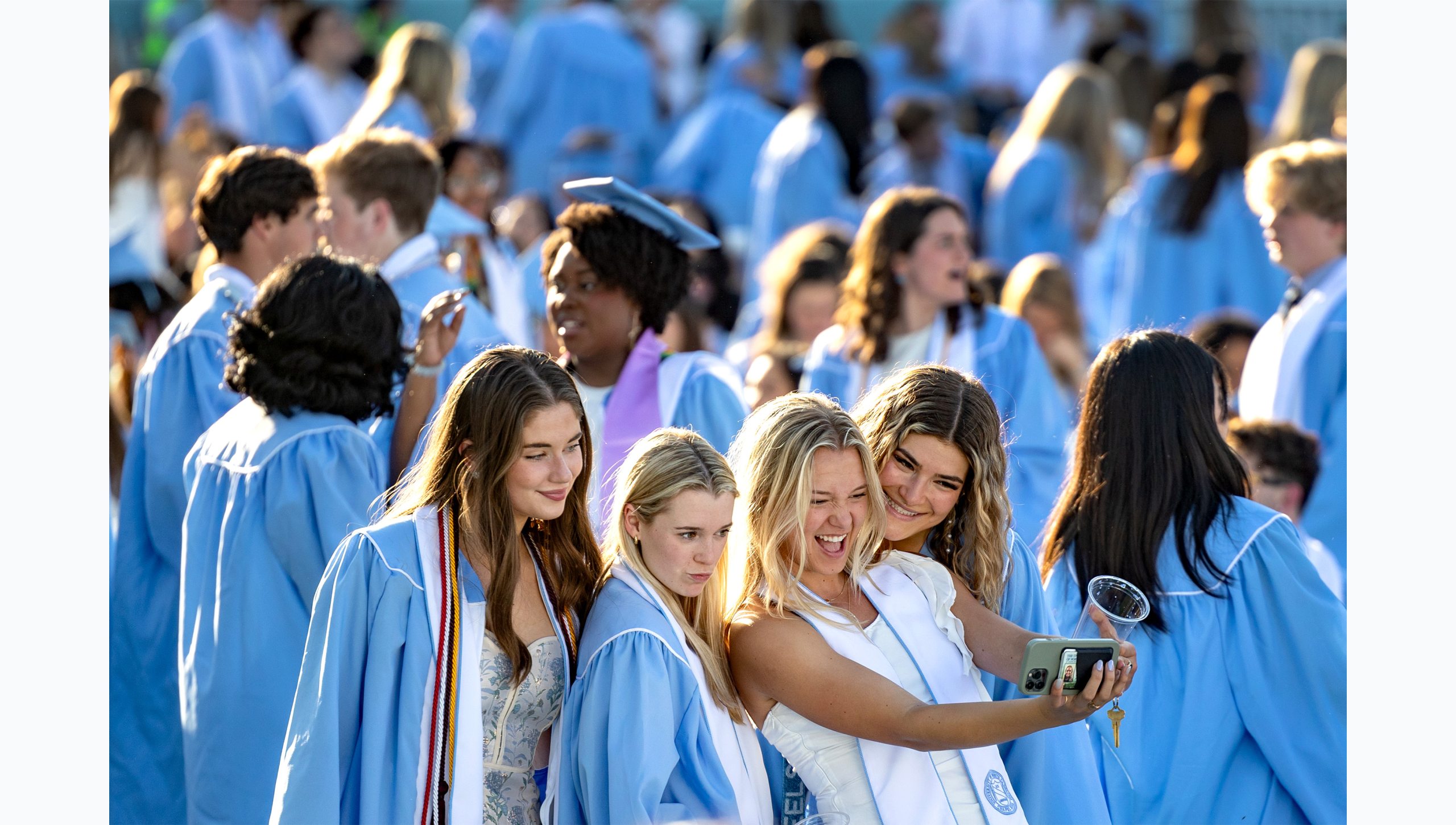 Graduates taking selfie together at Kenan Stadium