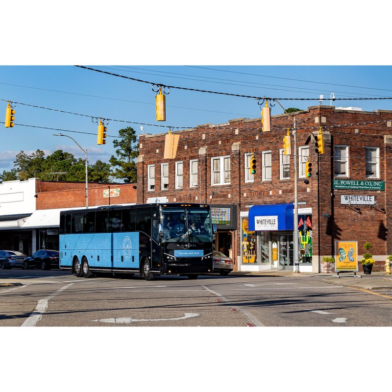 The Tar Heel Bus Tour bus driving through a street in Whiteville, N.C.