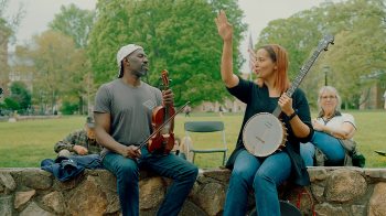 Rhiannon Giddens and Justin Robinson play instruments outside Wilson Library