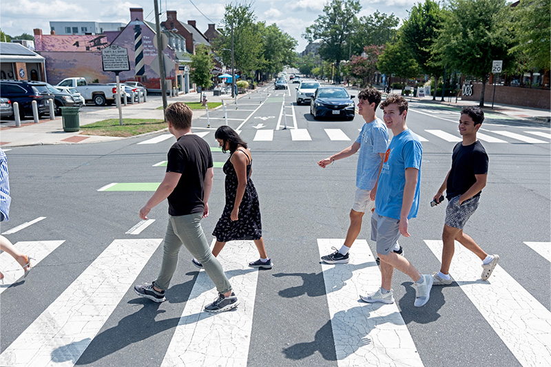 A group of students walking across a crosswalk on Franklin Street in downtown Chapel Hill.