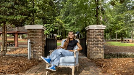 Mo’Asia Bagley sitting in a Carolina Blue chair at a park in Fuquay-Varina.