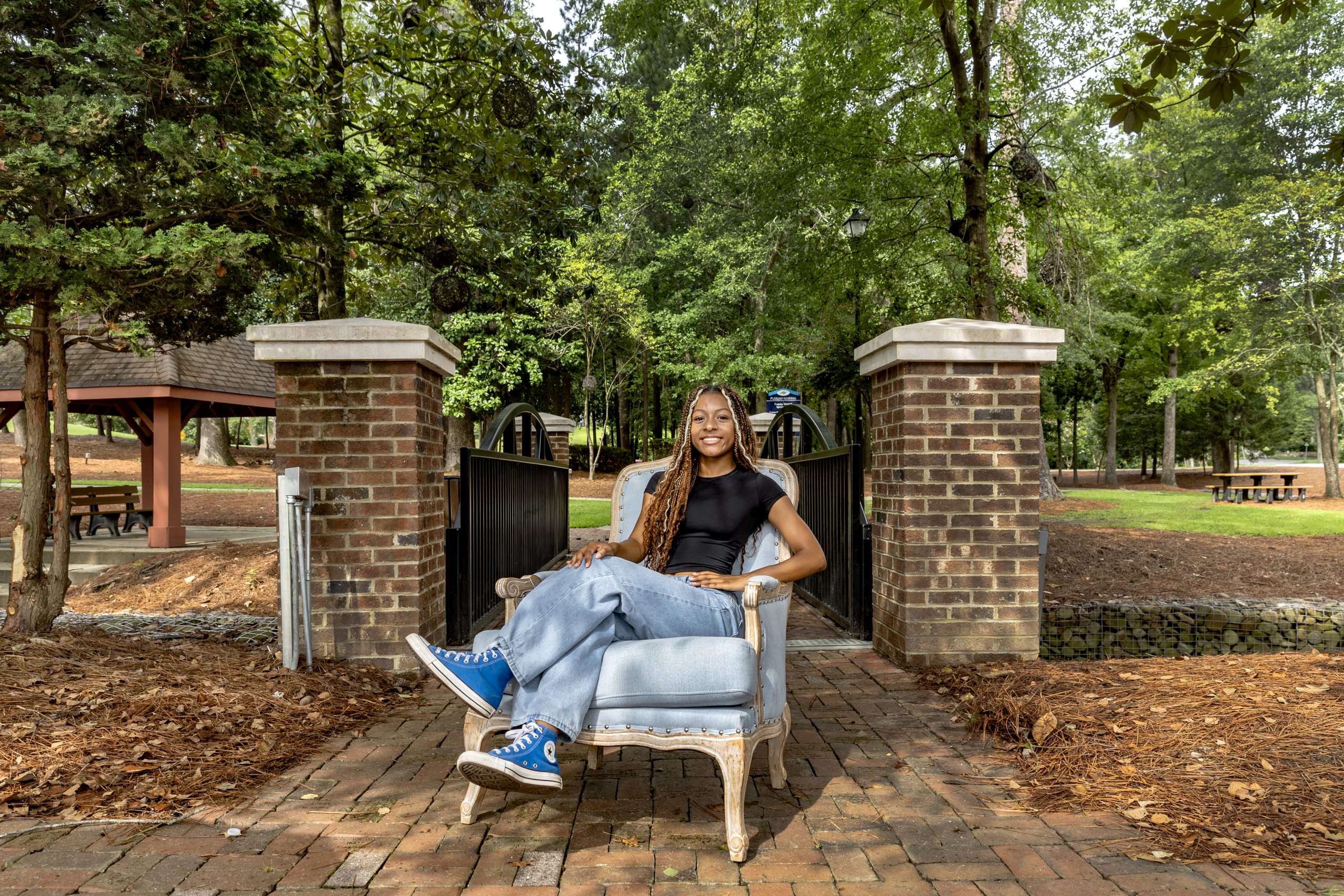 Mo’Asia Bagley sitting in a Carolina Blue chair at a park in Fuquay-Varina.