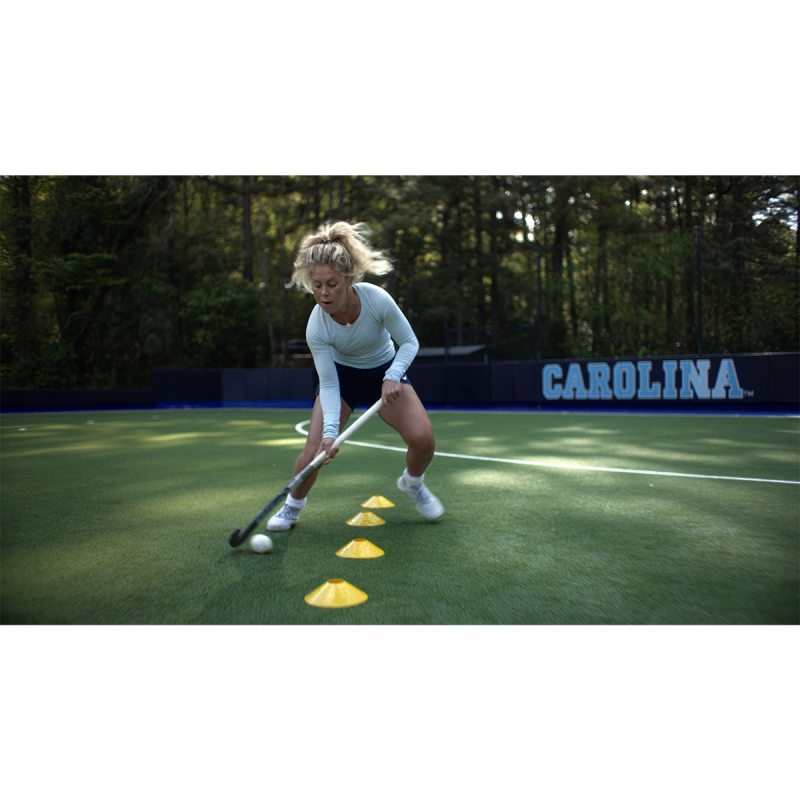 Katie Dixon doing field hockey drills on a practice field.