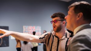 Logan Moore, donning a pair of Enchroma glasses, looks in amazement at art in the Ackland.