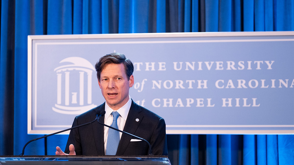 Lee Roberts speaks in front of UNC-Chapel Hill banner