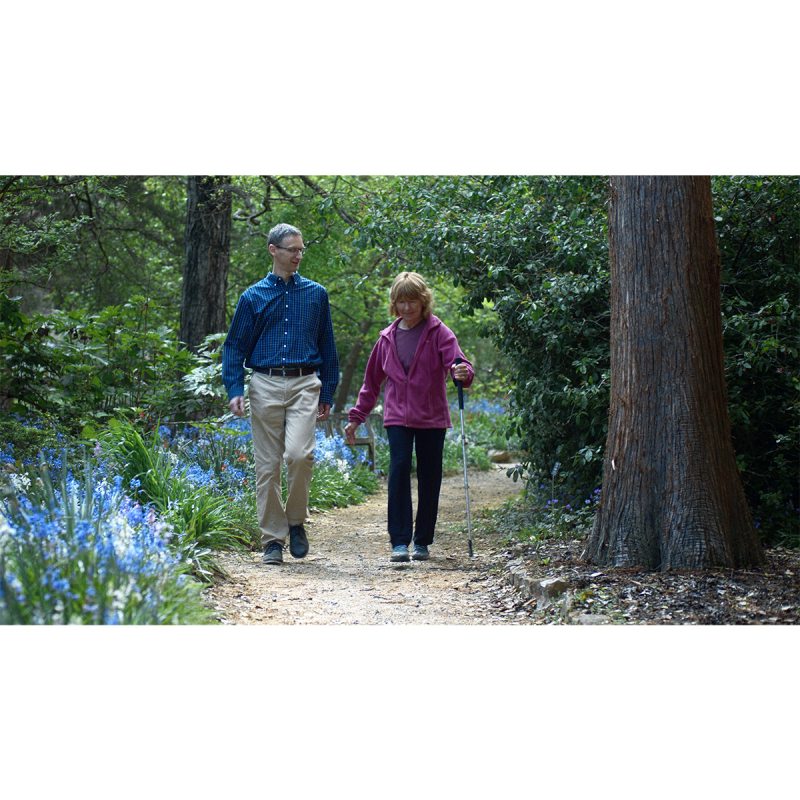 A researcher, Michael Lewek, walking on a nature trail with a patient.