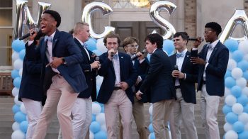 A cappella group performs in front of South Building