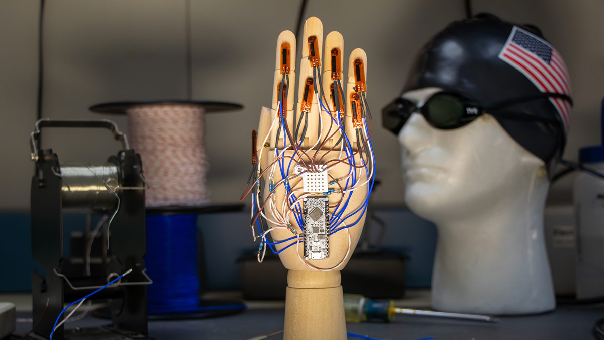 A hand mannequin with wires connected to a circuit board.