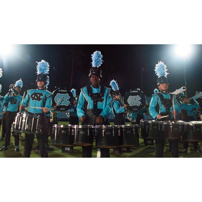 Torin Simpson and other members of the Marching Tar Heels band in uniform and performing.