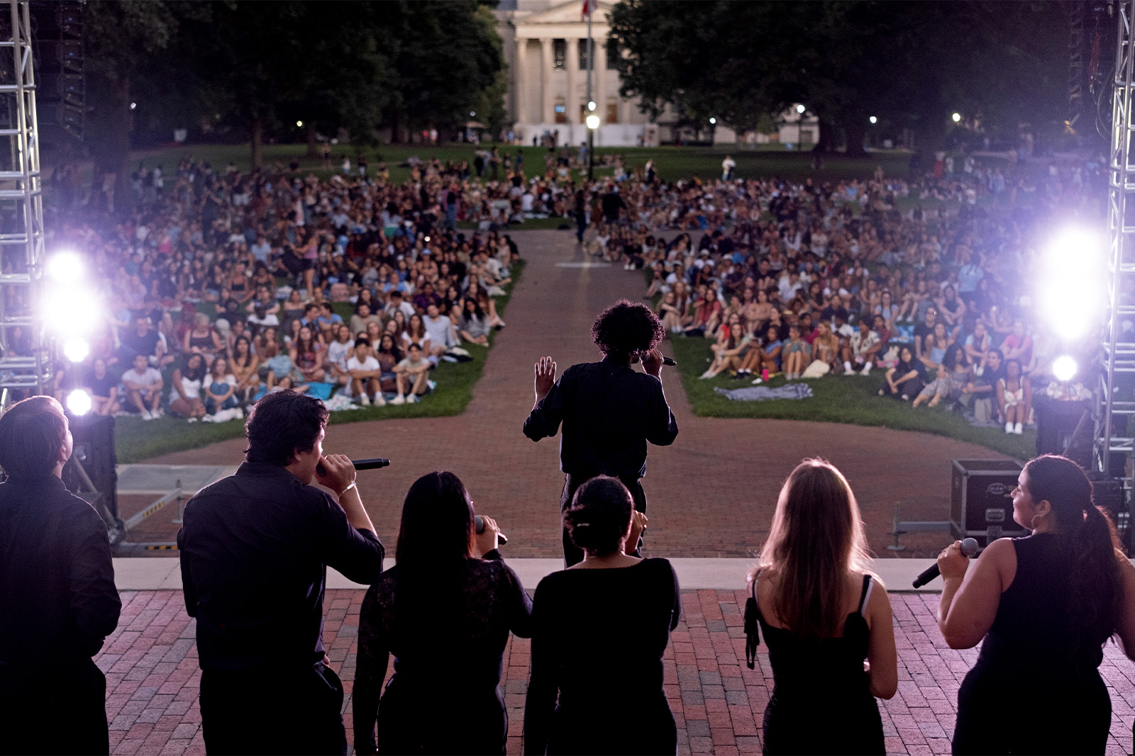 A student a cappella group performing in front of an audience on Polk Place on the campus of UNC-Chapel Hill at Sunset Serenade.