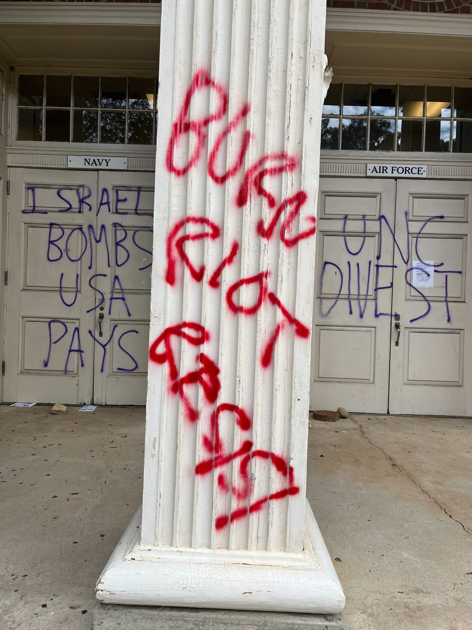 Column of a building with "BURN RIOT RESIST" spray painted in red paint