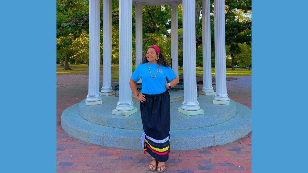 Lyric Locklear posing for a photo in front of the Old Well on the campus of UNC-Chapel Hill.