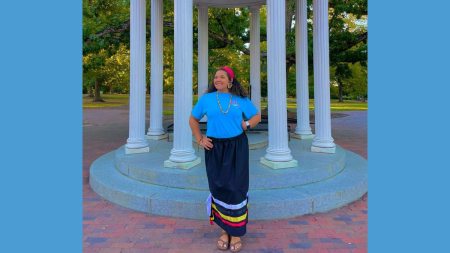 Lyric Locklear posing for a photo in front of the Old Well on the campus of UNC-Chapel Hill.