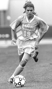 Mia Hamm dribbles soccer ball while wearing Carolina uniform