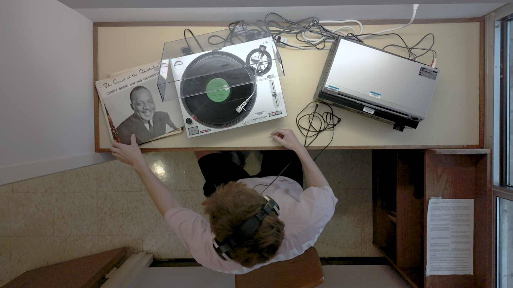 Bird's eye view of man sitting with record player.