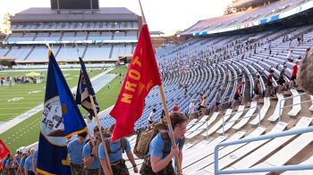 Individuals carrying flags up on the steps of Kenan stadium.