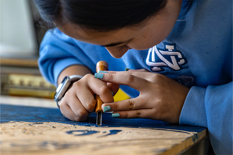 Close-up image of a student, Sophia Oh, working on an art piece.