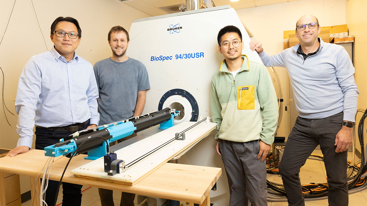 Ian Shih, Scott Tyler Albert, Sheng Song and Adam Hantman pose in front of an MRI machine in the Shih Lab.