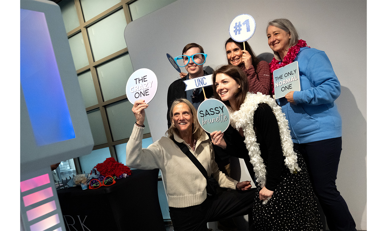 Carolina employees pose with signs at photo booth