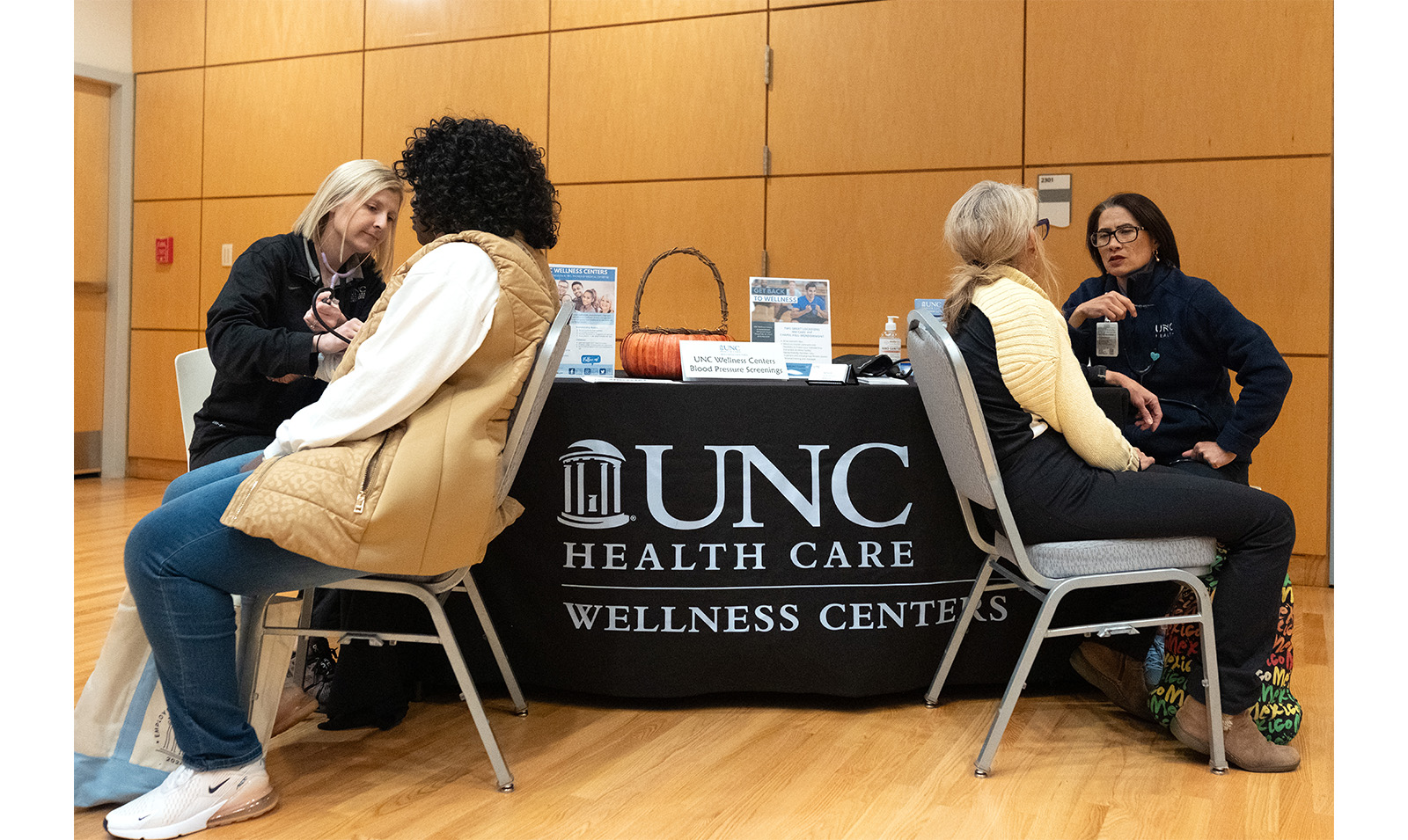 Carolina employees receive flu shots at table with UNC Health Care banner