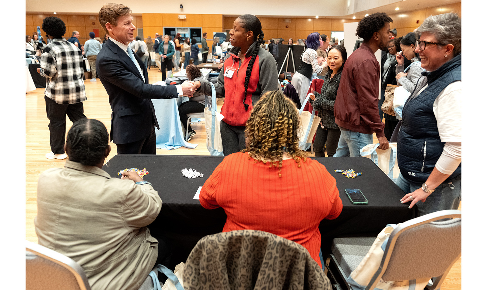 Chancellor Lee H. Roberts shakes an employee's hand in front of a table at Employee Appreciation Day