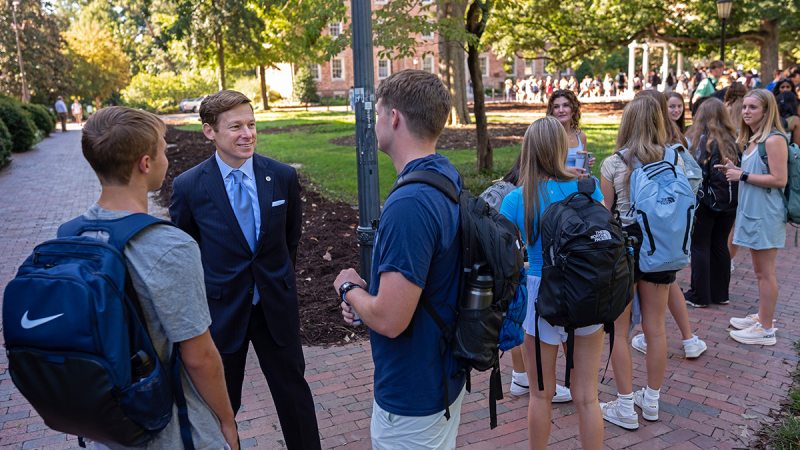 Lee H. Roberts meets with students near the Old Well