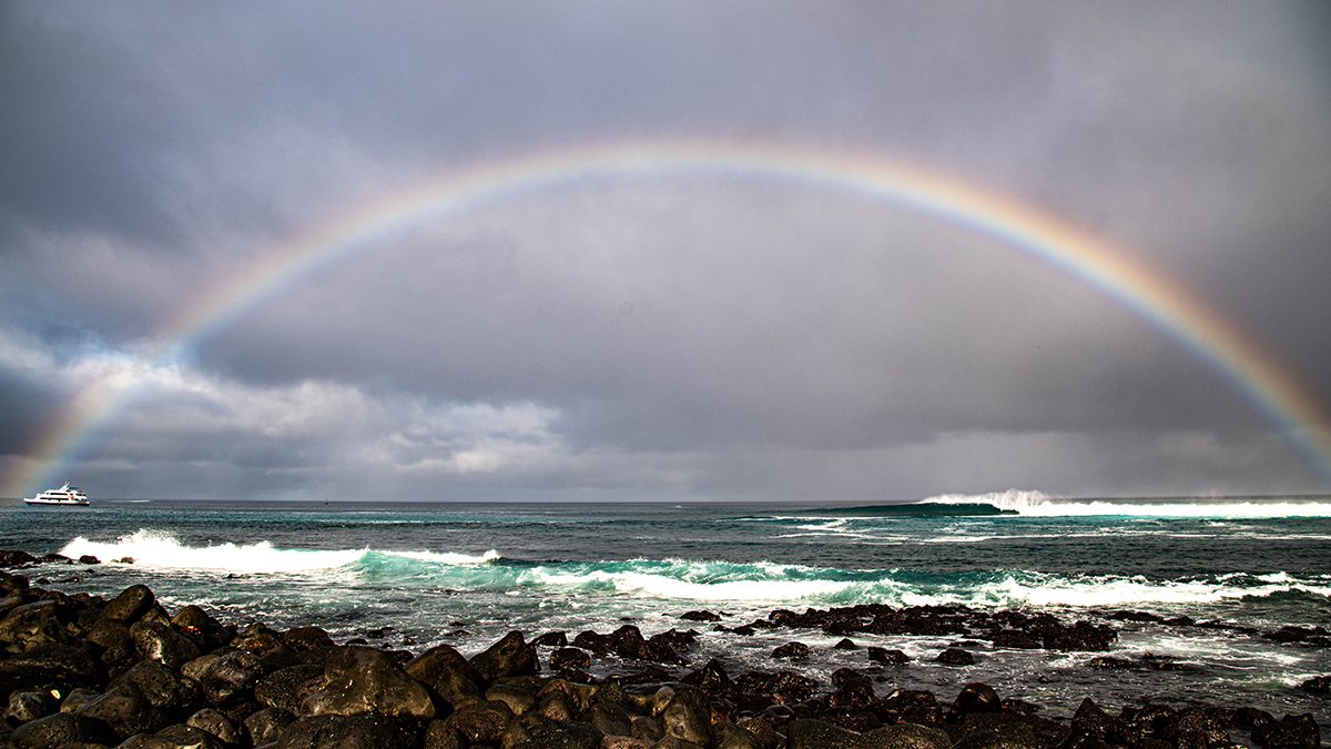 Rainbow stretching across Punta Carola Beach in San Cristobal, Galapagos.