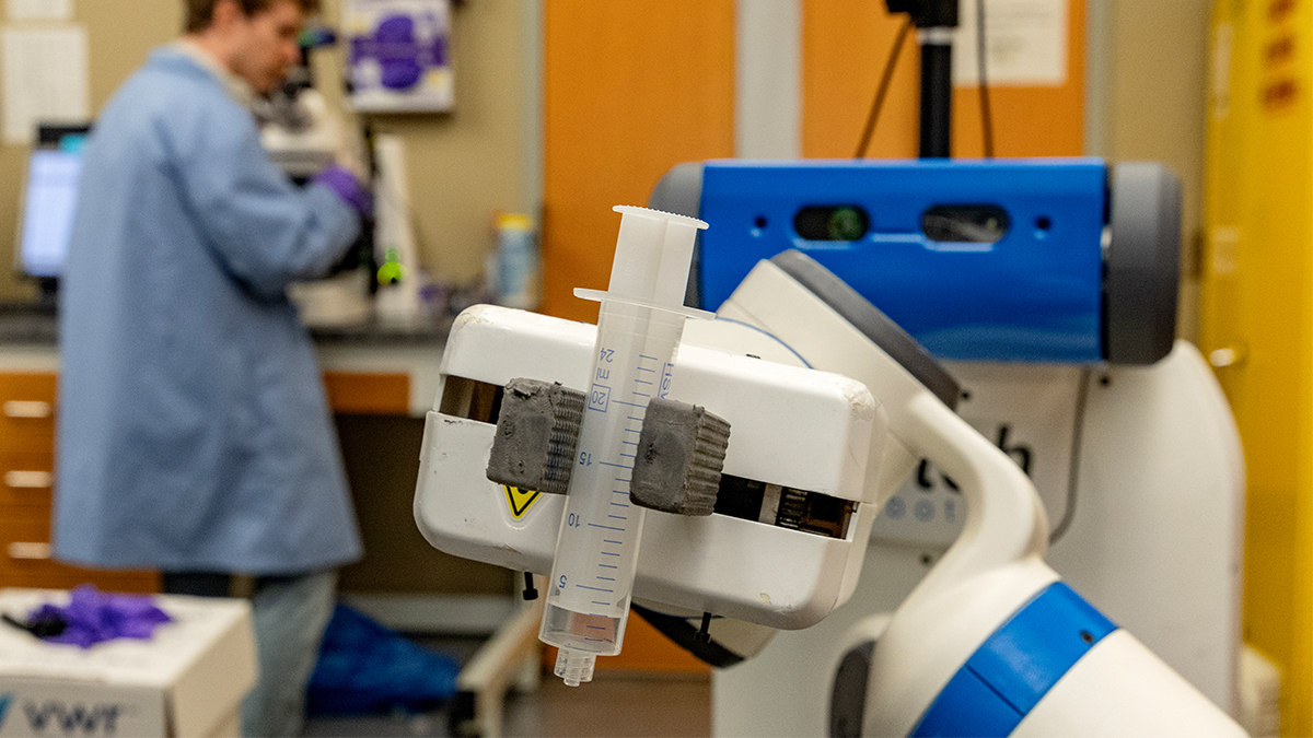 Automaton arm holding a syringe. 