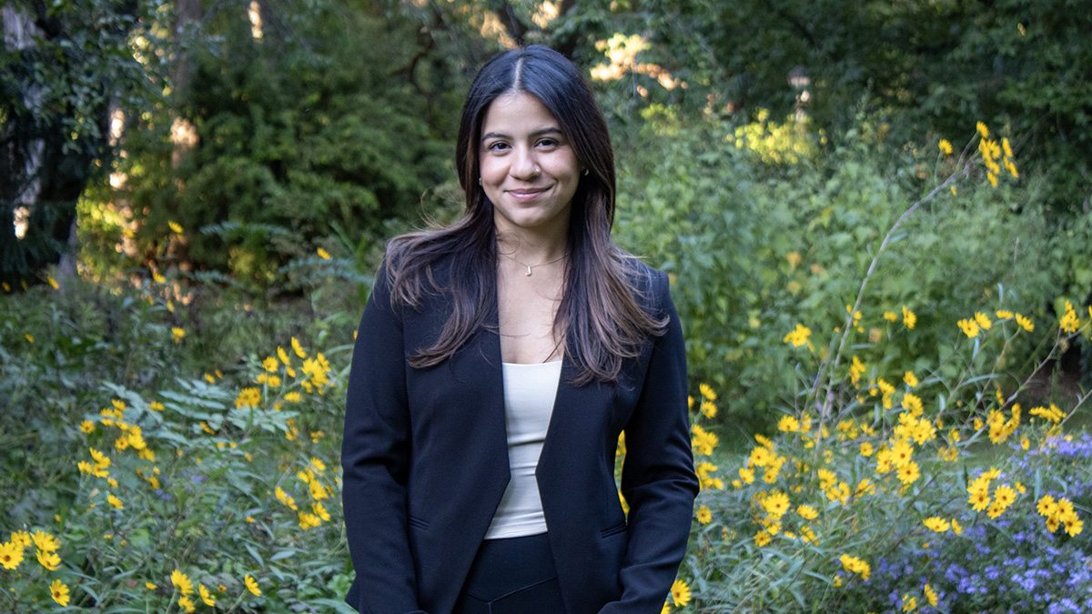 Michelle Gil Munoz wearing black blazer against greenery backdrop.