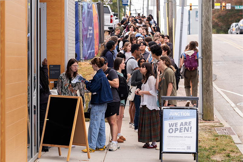 Long line of students extending down the sidewalk on Rosemary Street. The students were waiting for the opening of Meantime Coffee's location at the Junction.