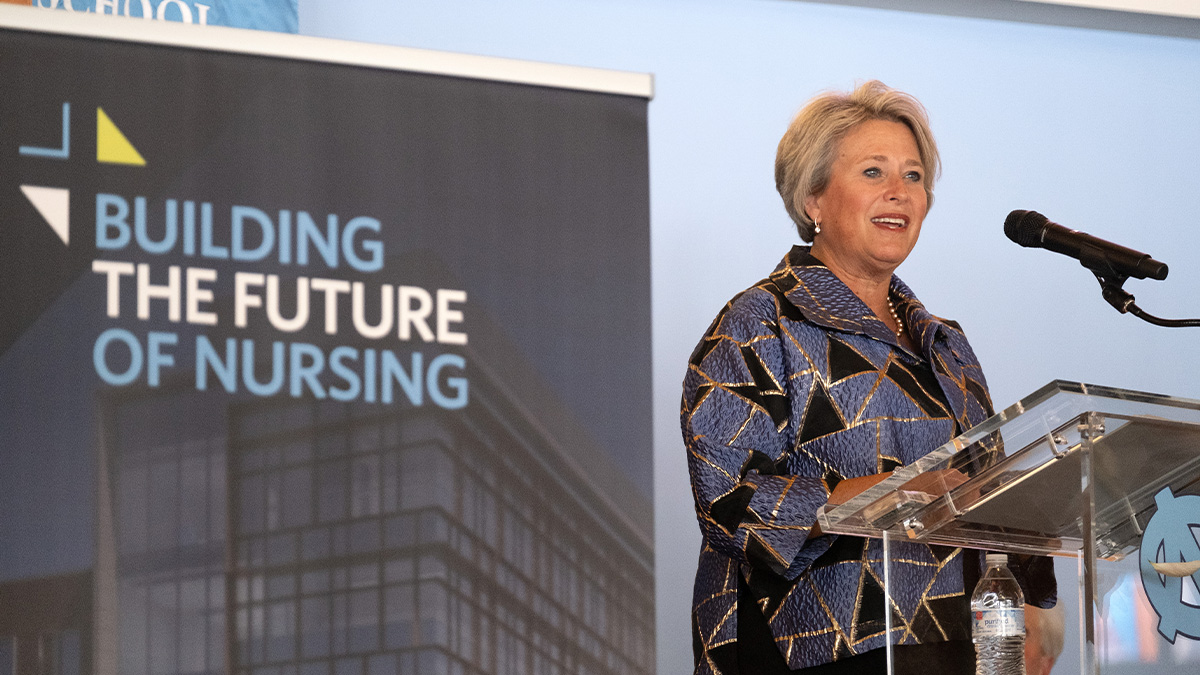 UNC School of Nursing dean Valerie Howard speaking from a podium at a building groundbreaking event.