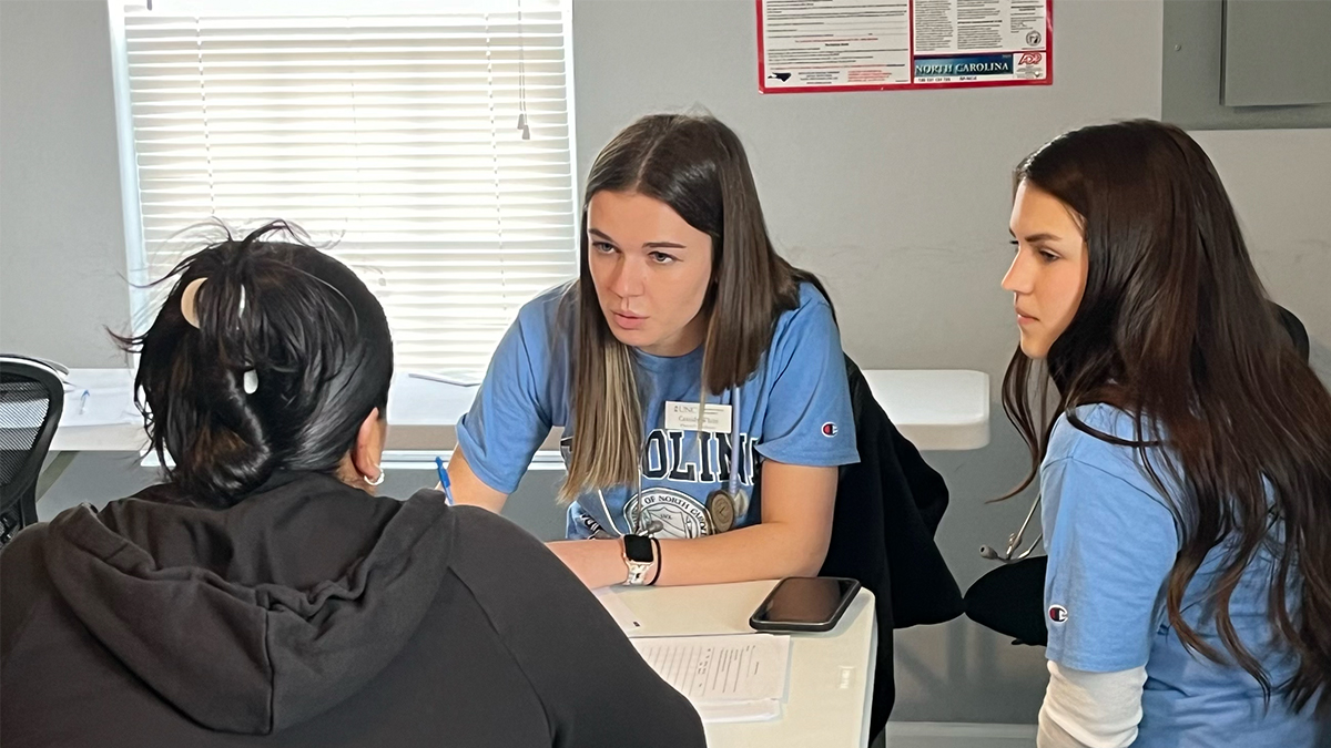 In between two students, Cassidy White works with two fellow students.