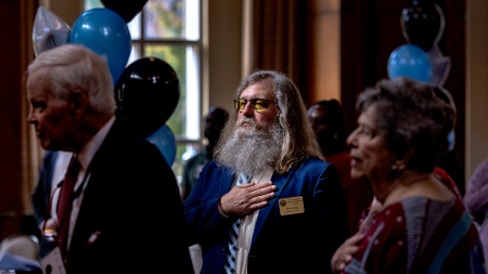 Man in suit holding his hand to his heart.