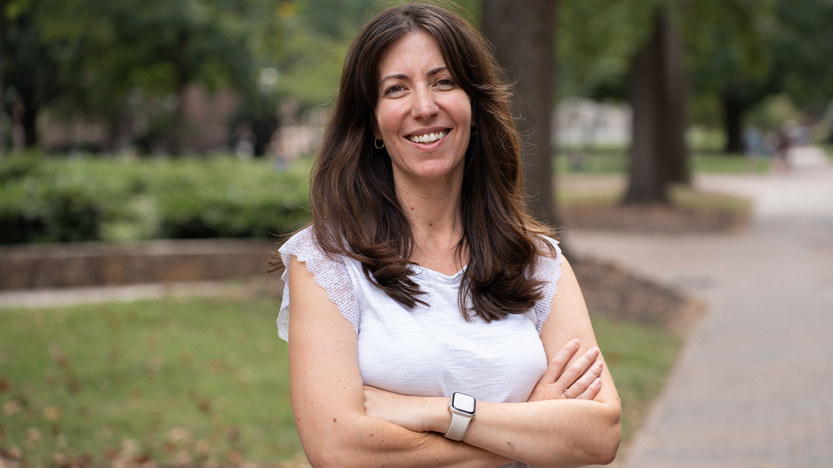 Francesca Tripodi posing for a portrait near a brick pathway on the campus of UNC-Chapel Hill